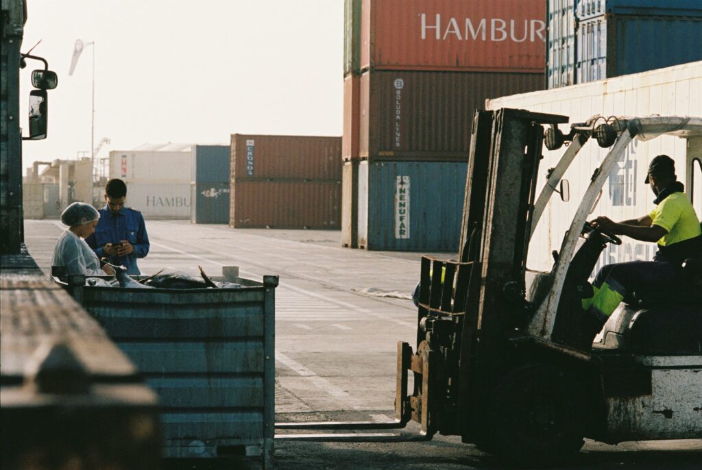 pexels photo 16015233 16015233 Workers operating a forklift in a shipping container yard at Praia port, Cabo Verde.